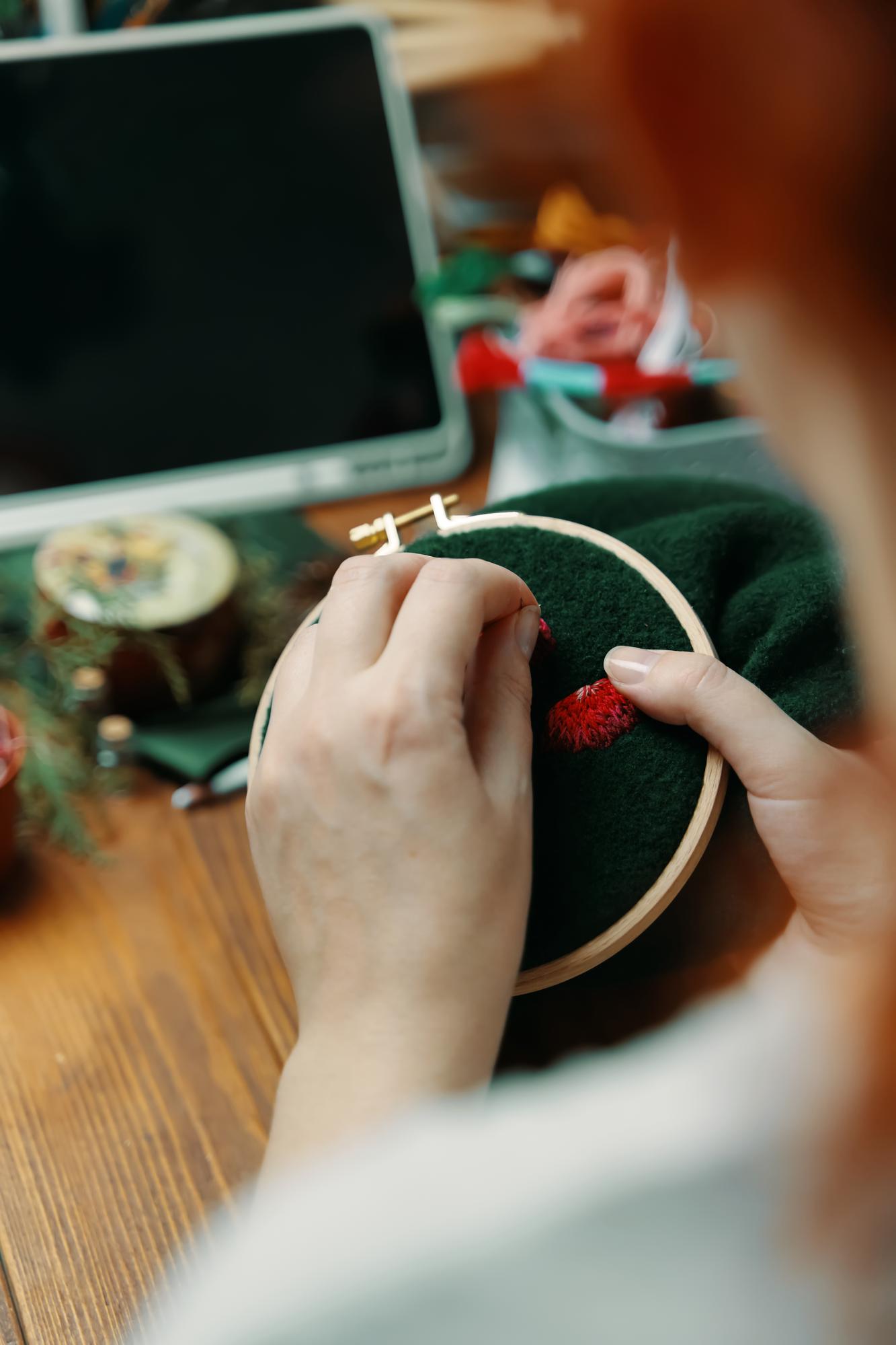 studio hands working on embroidered motif